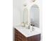 Modern bathroom boasts a double sink vanity with stylish wood cabinetry and arched mirrors at 1695 E Eastman Ave, Englewood, CO 80113