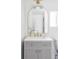 Charming bathroom features a vanity with gold hardware, an arched mirror and abundant natural light at 1695 E Eastman Ave, Englewood, CO 80113