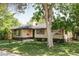 Beautifully landscaped home with large tree, manicured lawn, and classic brick exterior at 1695 E Eastman Ave, Englewood, CO 80113
