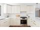 Beautiful kitchen featuring modern appliances, quartz counters, and sleek white cabinets with gold hardware at 1695 E Eastman Ave, Englewood, CO 80113