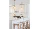 Bright kitchen featuring white cabinets, quartz countertops, and modern pendant lighting at 1695 E Eastman Ave, Englewood, CO 80113