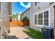 Low-maintenance backyard features artificial grass, a brick paver patio and a wood fence at 8421 E 29Th Ave, Denver, CO 80238