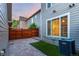 Cozy backyard featuring a brick paver patio, privacy fence, and compact synthetic grass area at 8421 E 29Th Ave, Denver, CO 80238