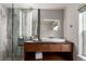 Bathroom with modern sink, vanity, and decorative accent stones in the glass-enclosed shower at 8421 E 29Th Ave, Denver, CO 80238