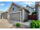 Attached two-car garage with gray siding and well-maintained landscaping featuring stone accents at 8421 E 29Th Ave, Denver, CO 80238