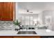 Kitchen with white countertops, wood cabinets and stainless steel sink overlooking the living room at 8421 E 29Th Ave, Denver, CO 80238