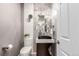 Modern powder room with geometric mirrors, unique lighting, and black sink basin at 8421 E 29Th Ave, Denver, CO 80238