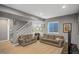 Basement rec room featuring two couches, a staircase, and a window at 4808 S Picadilly Ct, Aurora, CO 80015