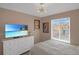Bright bedroom featuring a TV and a large window overlooking the neighborhood at 4808 S Picadilly Ct, Aurora, CO 80015