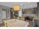 Modern kitchen and dining area with dark cabinets, granite countertops, stainless appliances, and sleek lighting at 4808 S Picadilly Ct, Aurora, CO 80015