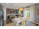 Open kitchen and dining area with dark cabinets, granite countertops, stainless appliances, and patio access at 4808 S Picadilly Ct, Aurora, CO 80015