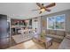 Open living room and kitchen area with dark wood floors, modern furniture, and ample natural light at 4808 S Picadilly Ct, Aurora, CO 80015