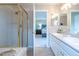 Well-lit bathroom showcasing a glass shower enclosure, double sinks and a view to the bedroom at 1169 Thornbury Pl, Highlands Ranch, CO 80129