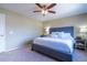 Comfortable bedroom with a ceiling fan, cozy carpet, and a stylish upholstered bed frame at 1169 Thornbury Pl, Highlands Ranch, CO 80129