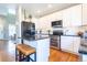 Modern kitchen with white cabinets, stainless steel appliances, and a black countertop island at 1169 Thornbury Pl, Highlands Ranch, CO 80129