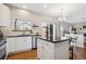 Well-lit kitchen with white cabinetry, stainless steel appliances, and an island with seating at 1169 Thornbury Pl, Highlands Ranch, CO 80129