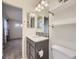 Modern bathroom with vanity, large mirror, decorative tile backsplash, toilet, and open doorway to a bedroom at 3921 E 141St Ave, Thornton, CO 80602