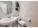 Powder room featuring a pedestal sink, toilet, and decorative accents for a simple and efficient design at 3921 E 141St Ave, Thornton, CO 80602