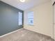 Neutral-toned bedroom with two windows, gray carpet, and an accent wall, creating a peaceful atmosphere at 3921 E 141St Ave, Thornton, CO 80602