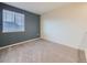 A well-lit bedroom features neutral carpet, a blue accent wall, and a window offering natural light at 3921 E 141St Ave, Thornton, CO 80602