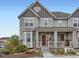 This two-story home is painted gray with brick accents and a covered front porch at 3921 E 141St Ave, Thornton, CO 80602