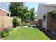 Landscaped backyard with a wooden fence, patio seating, and lush green lawn at 3785 E 134Th Ct, Thornton, CO 80241