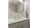 Modern bathroom vanity with a round mirror, stylish faucet, and elegant towel ring at 3785 E 134Th Ct, Thornton, CO 80241
