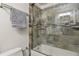 Updated bathroom featuring a bathtub with stone tile surround and glass door at 3785 E 134Th Ct, Thornton, CO 80241