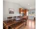 Cozy dining area with wood floors, rustic table, flows into the kitchen with wooden cabinetry at 3785 E 134Th Ct, Thornton, CO 80241