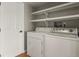 Functional laundry room with washer, dryer, shelves, and a convenient door at 3785 E 134Th Ct, Thornton, CO 80241