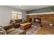 Comfortable living room with a brick fireplace, wood floors, and natural light at 3785 E 134Th Ct, Thornton, CO 80241