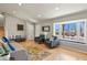 Sunlit living room with hardwood floors, comfortable seating, and a large window with a charming neighborhood view at 3785 E 134Th Ct, Thornton, CO 80241