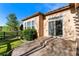 The backyard patio leads to a well manicured lawn, lush landscape and wood fence under a bright blue sky at 5662 W Peakview Pl, Littleton, CO 80123