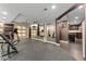 Home gym with mirrored wall, weight training equipment, wall-mounted television and bar with beverage refrigerator at 5662 W Peakview Pl, Littleton, CO 80123