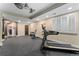 Home gym featuring workout equipment, large windows with shutters, ceiling fans, and a beverage refrigerator at 5662 W Peakview Pl, Littleton, CO 80123