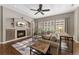 Bright living room with a fireplace, large windows with shutters, and hardwood floors at 5662 W Peakview Pl, Littleton, CO 80123