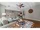 Open living room features a neutral palette, ceiling fan, hardwood floors, and a decorative area rug at 5662 W Peakview Pl, Littleton, CO 80123