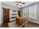 Home office features a wooden desk, sliding barn doors, and a window with shutter blinds at 5662 W Peakview Pl, Littleton, CO 80123