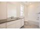 Bright bathroom with sleek vanity, white cabinets, and tub with tiled shower at 1989 S Haleyville Way, Aurora, CO 80018