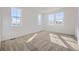 Bright bedroom featuring three large windows, neutral carpet, and ample sunlight at 1989 S Haleyville Way, Aurora, CO 80018