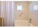 Well-lit bathroom featuring a safety grab bar and tiled walls around a soaking tub at 8611 Gold Peak Dr # D, Highlands Ranch, CO 80130