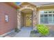 Inviting entryway featuring a stone archway, yellow door with wreath, and decorative landscaping at 8611 Gold Peak Dr # D, Highlands Ranch, CO 80130
