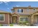 Charming townhome with stone accents, a yellow door, and well-maintained landscaping at 8611 Gold Peak Dr # D, Highlands Ranch, CO 80130