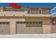 Exterior image of a home showing a tan garage with a carriage style garage door at 8611 Gold Peak Dr # D, Highlands Ranch, CO 80130