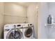Convenient laundry area with modern washer and dryer units and built-in shelving at 8611 Gold Peak Dr # D, Highlands Ranch, CO 80130