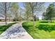 Scenic paved walking path winding through lush green spaces with mature trees at 8611 Gold Peak Dr # D, Highlands Ranch, CO 80130