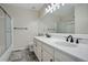 Bathroom showcasing double sinks, modern fixtures, and a glass shower enclosure at 18292 E Caspian Pl, Aurora, CO 80013