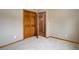 Bedroom with neutral carpet and walls, wood trim, and closet with wood doors at 18292 E Caspian Pl, Aurora, CO 80013