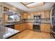This kitchen features wood floors, oak cabinetry, granite countertops, stainless appliances, and a window over the sink at 18292 E Caspian Pl, Aurora, CO 80013