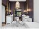 Bathroom with marble floors, a free-standing tub, dual vanities, and modern lighting at 7706 S Crocker Ct, Littleton, CO 80120